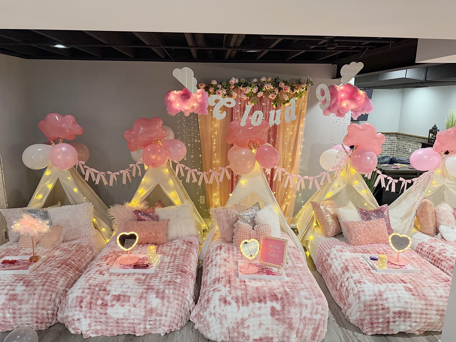 Cloud 9 sleepover setup with glowing cotton candy clouds, a script Cloud 9 sign, heart mirrors and pink tie-dye bedding